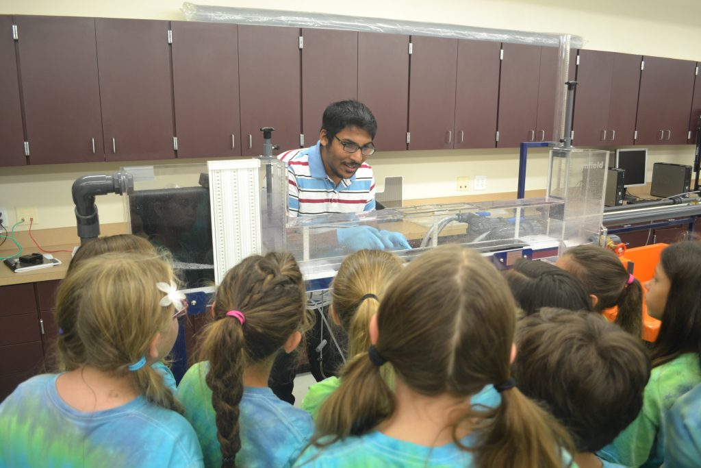 Lab member Tonmoy Sarker teaches elementary school children about hydraulics.  Photo by K.M. Kibler