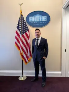 Ricky Ly inside the White House next to the American flag